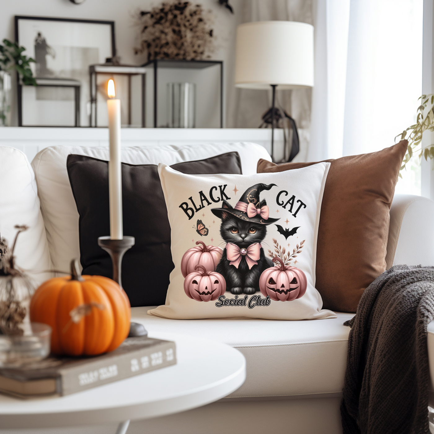 a white couch with a black cat pillow on it