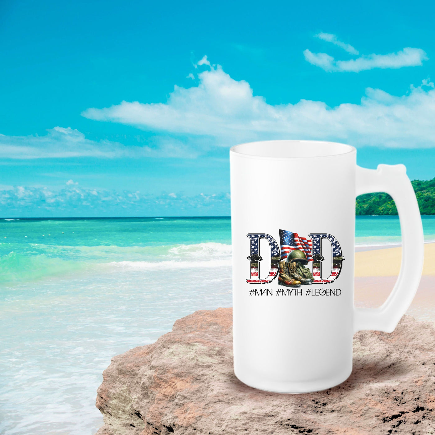 a white coffee mug sitting on top of a sandy beach