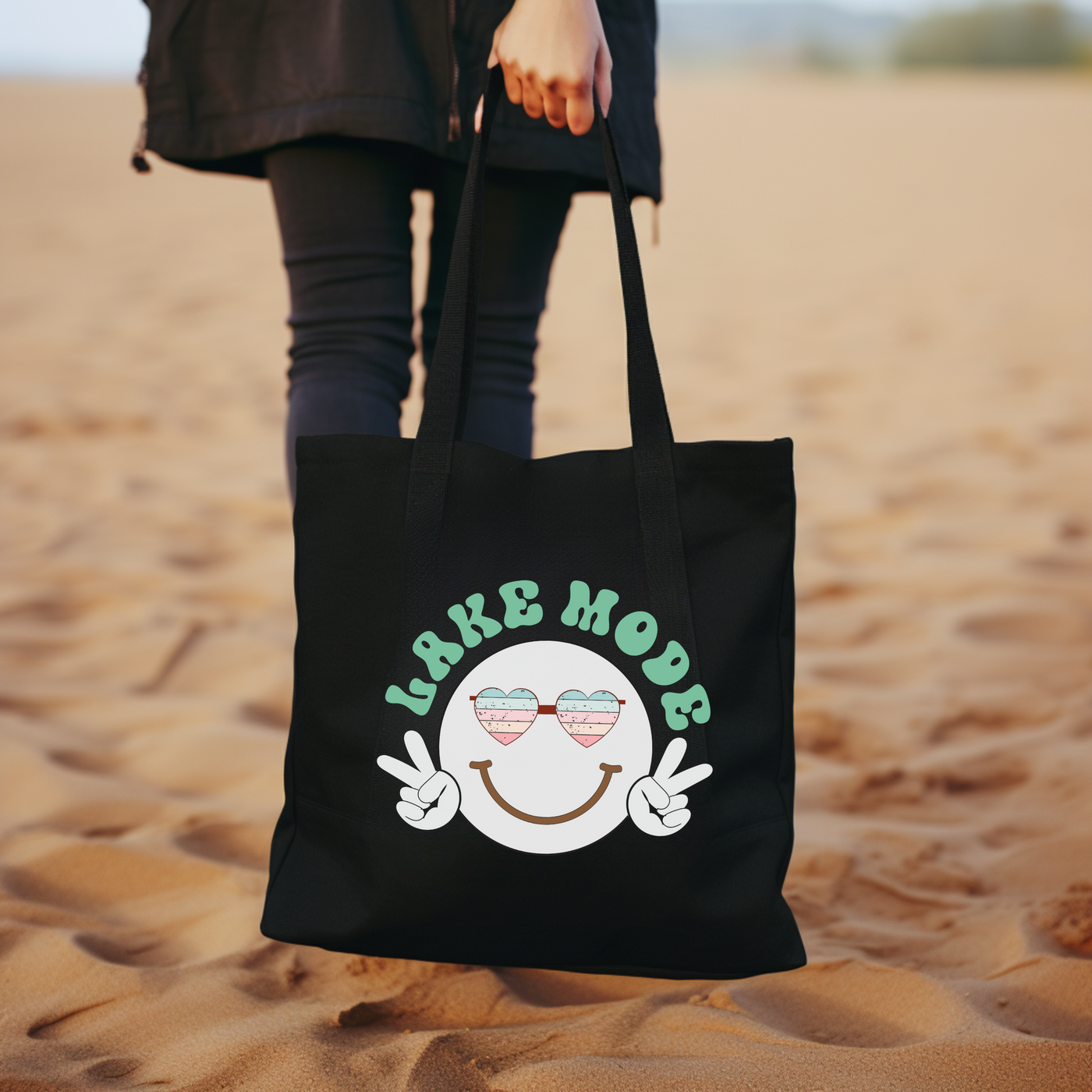 a woman carrying a black bag with a smiley face on it