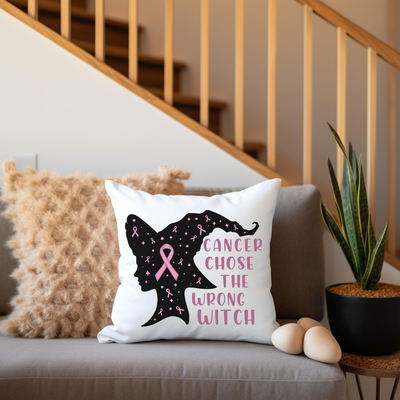 a pillow with a pink ribbon on it sitting on a couch