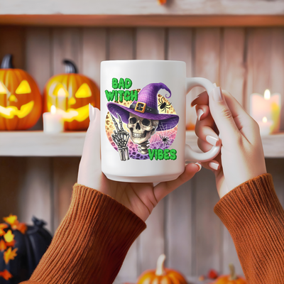 a person holding a coffee mug with a skeleton wearing a witches hat