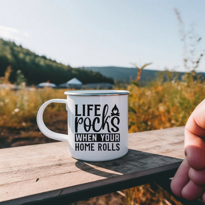 a hand holding a coffee mug that says life rocks when your home rolls