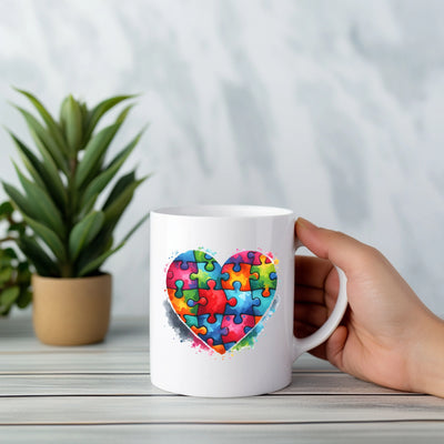 a person holding a coffee mug with a puzzle heart on it