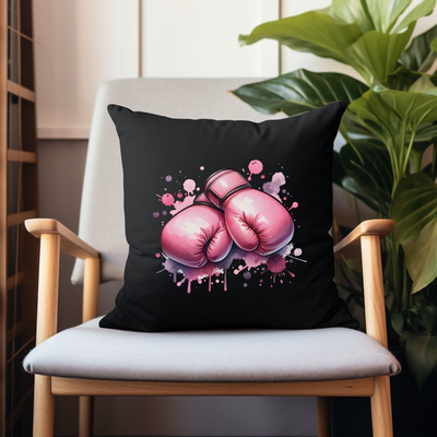 a black pillow with pink boxing gloves on it