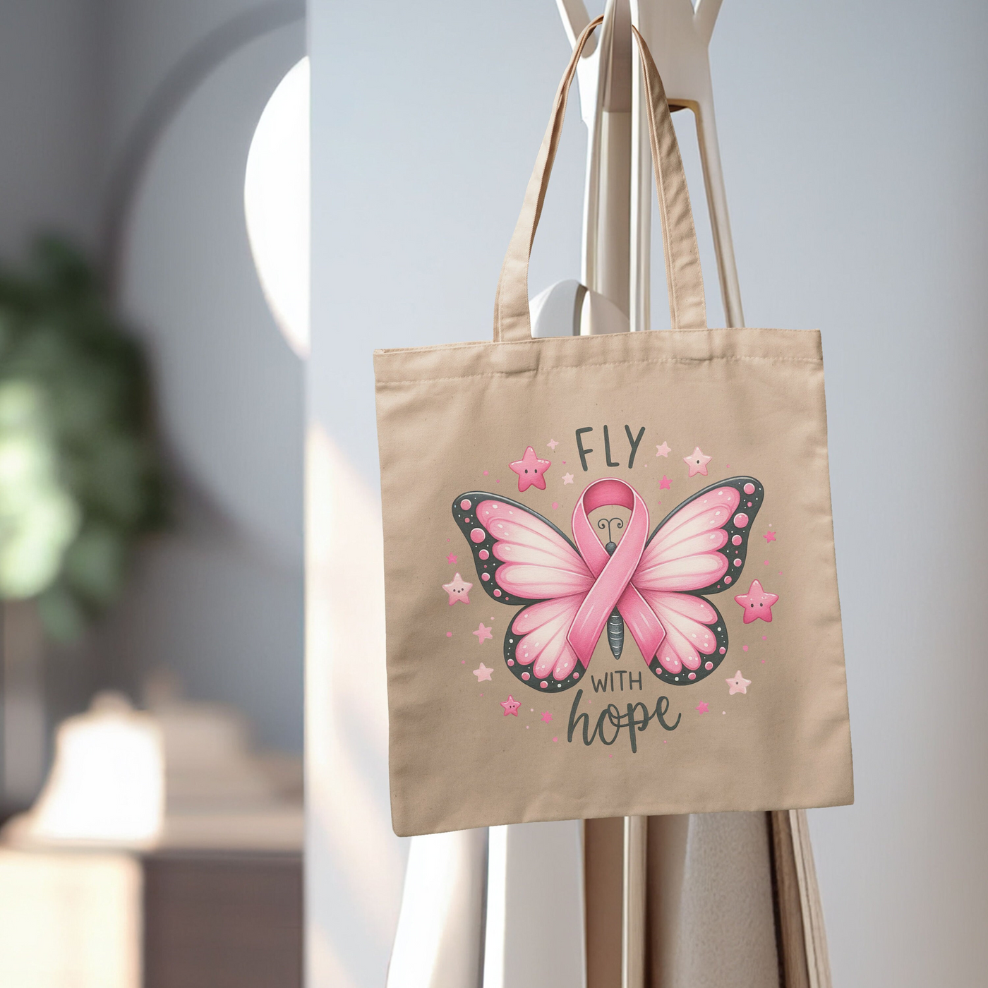 a canvas bag with a pink ribbon on it