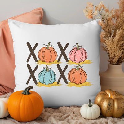 a white pillow with four pumpkins on it