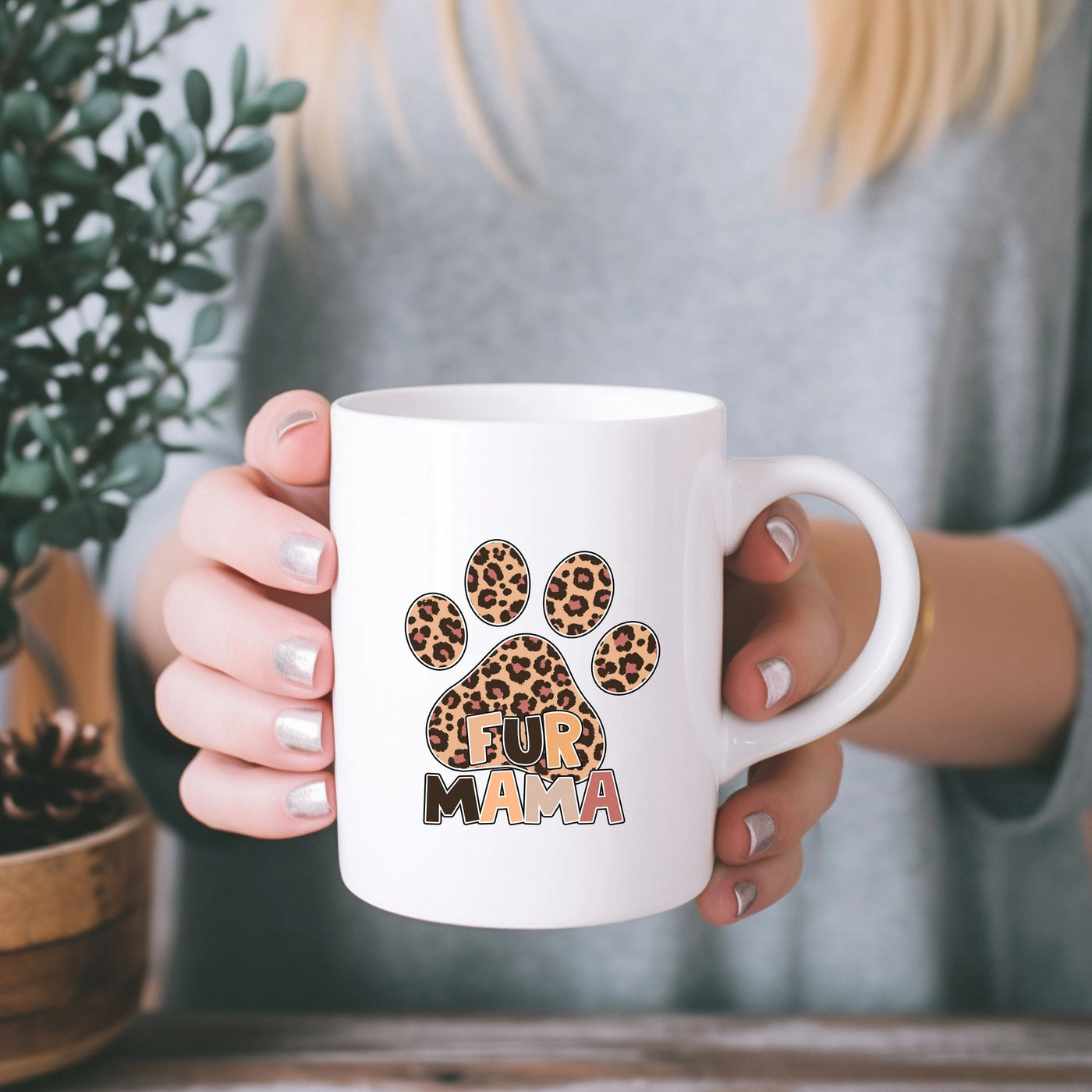 a woman holding a coffee mug with a paw print