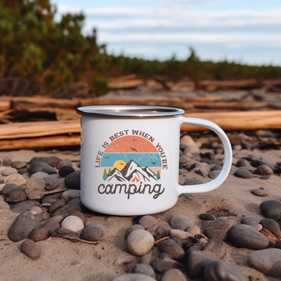 a white camp mug sitting on top of a pile of rocks