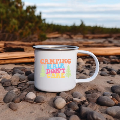 a white camp mug sitting on top of a pile of rocks