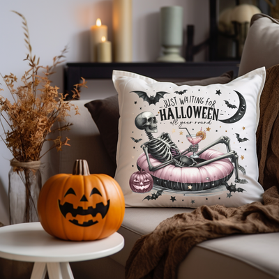 a halloween pillow sitting on a couch next to a pumpkin