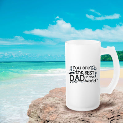 a white coffee mug sitting on top of a beach