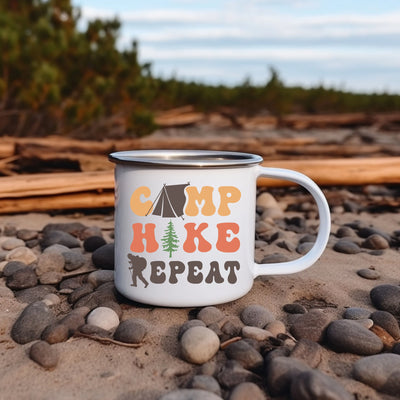 a camp mug sitting on a rocky beach