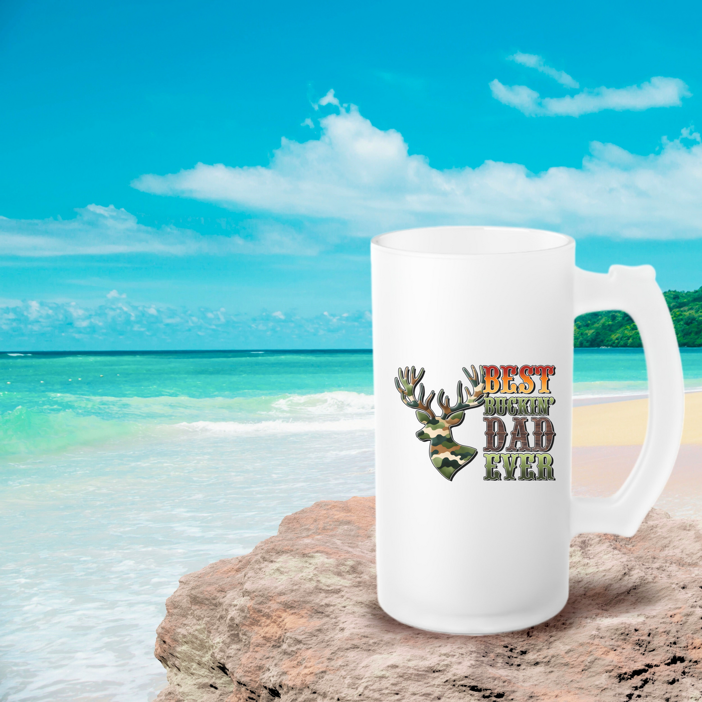 a white coffee mug sitting on top of a sandy beach