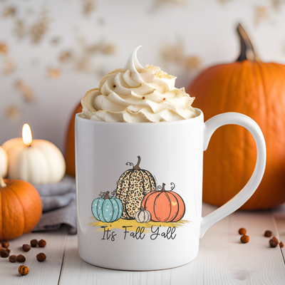 a cup of coffee with whipped cream and pumpkins