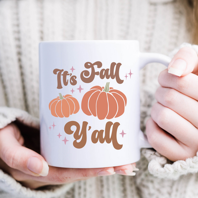 a woman is holding a coffee mug with a pumpkin on it