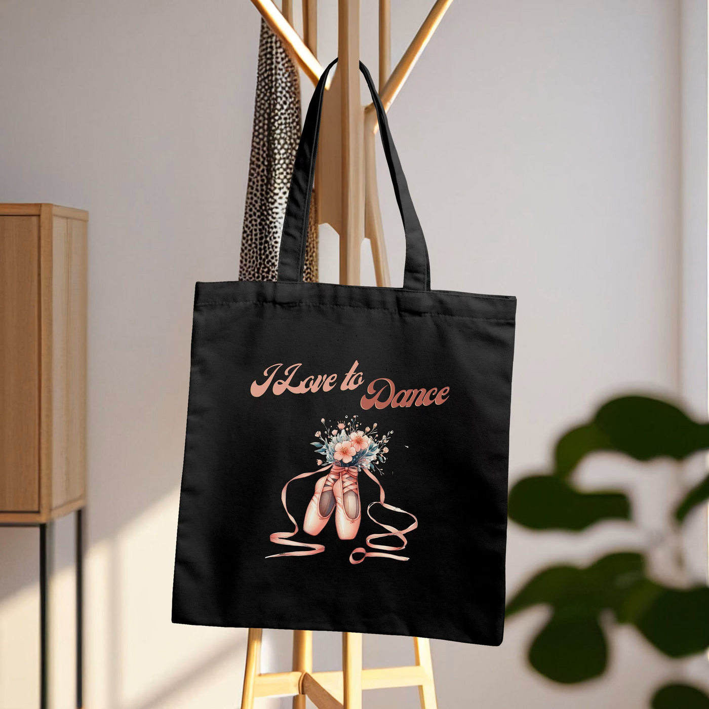 a black tote bag hanging from a clothes rack