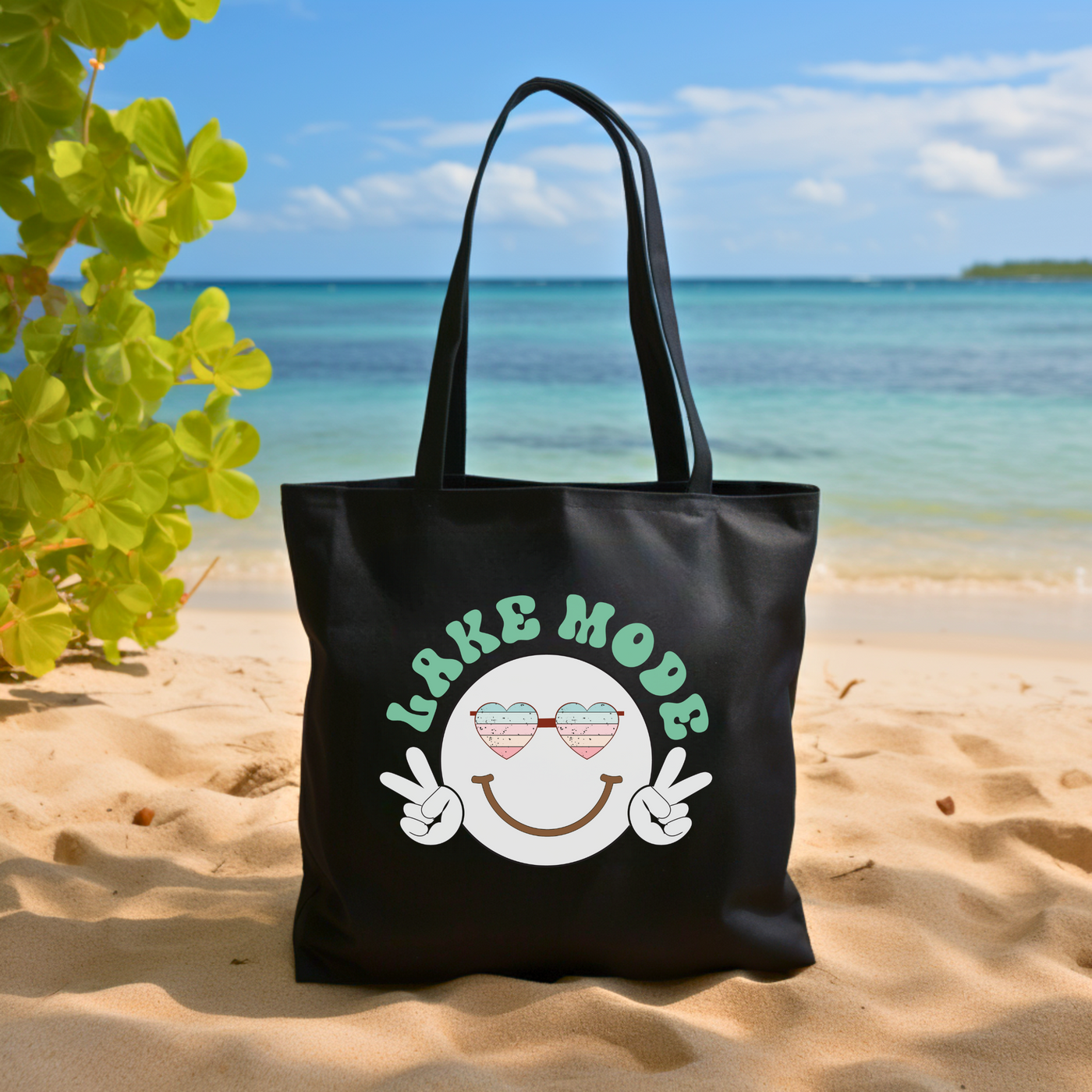 a black tote bag sitting on top of a sandy beach