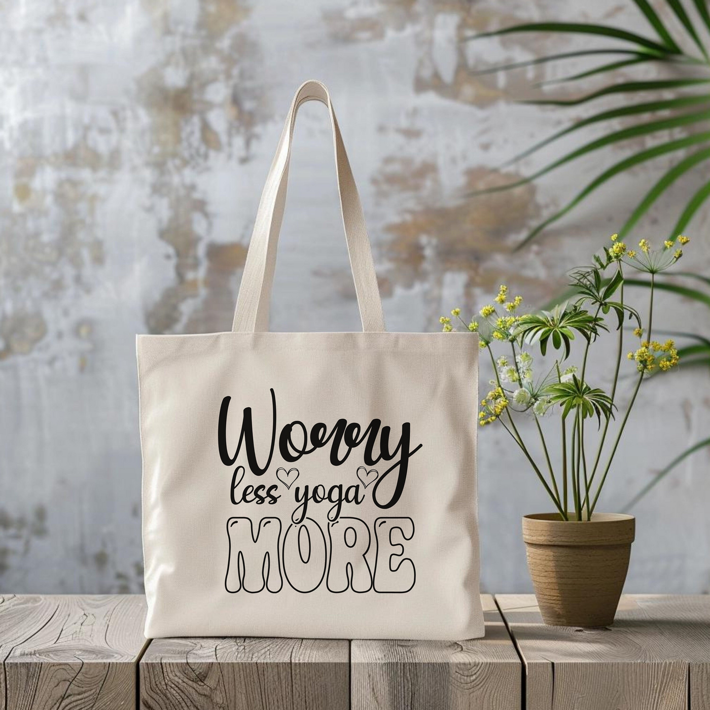 a white tote bag sitting next to a potted plant