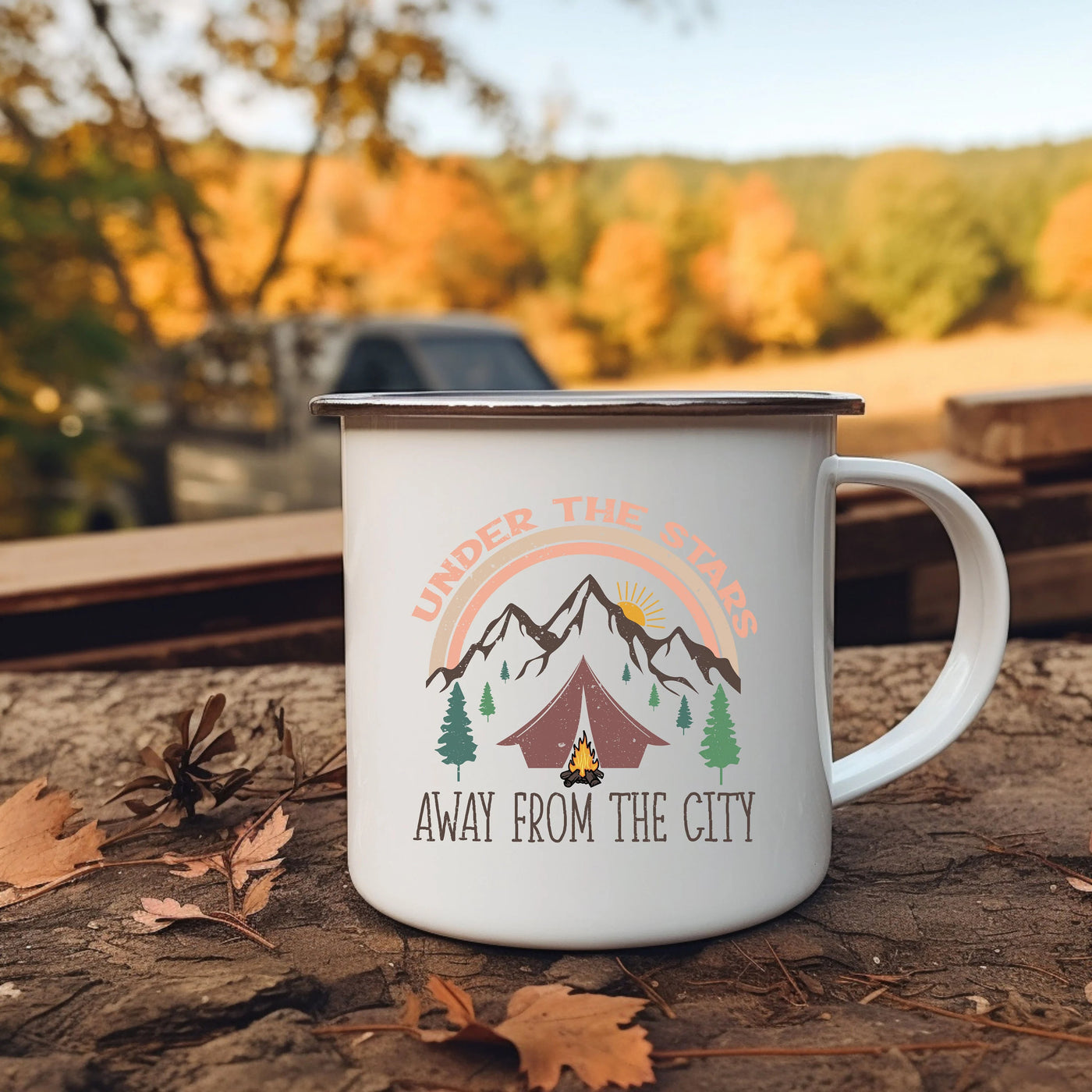 a camp mug sitting on the ground next to leaves