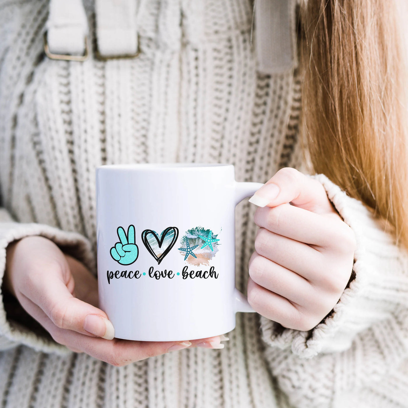 a woman holding a coffee mug with peace love beach on it