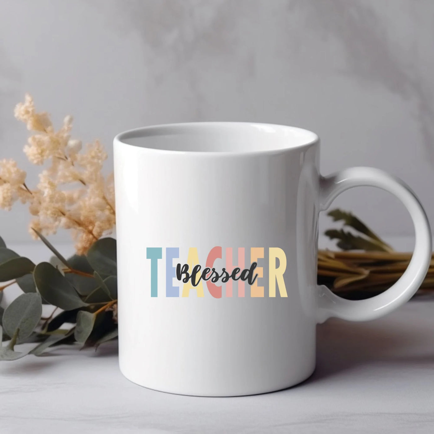 a white coffee mug with the word teacher printed on it