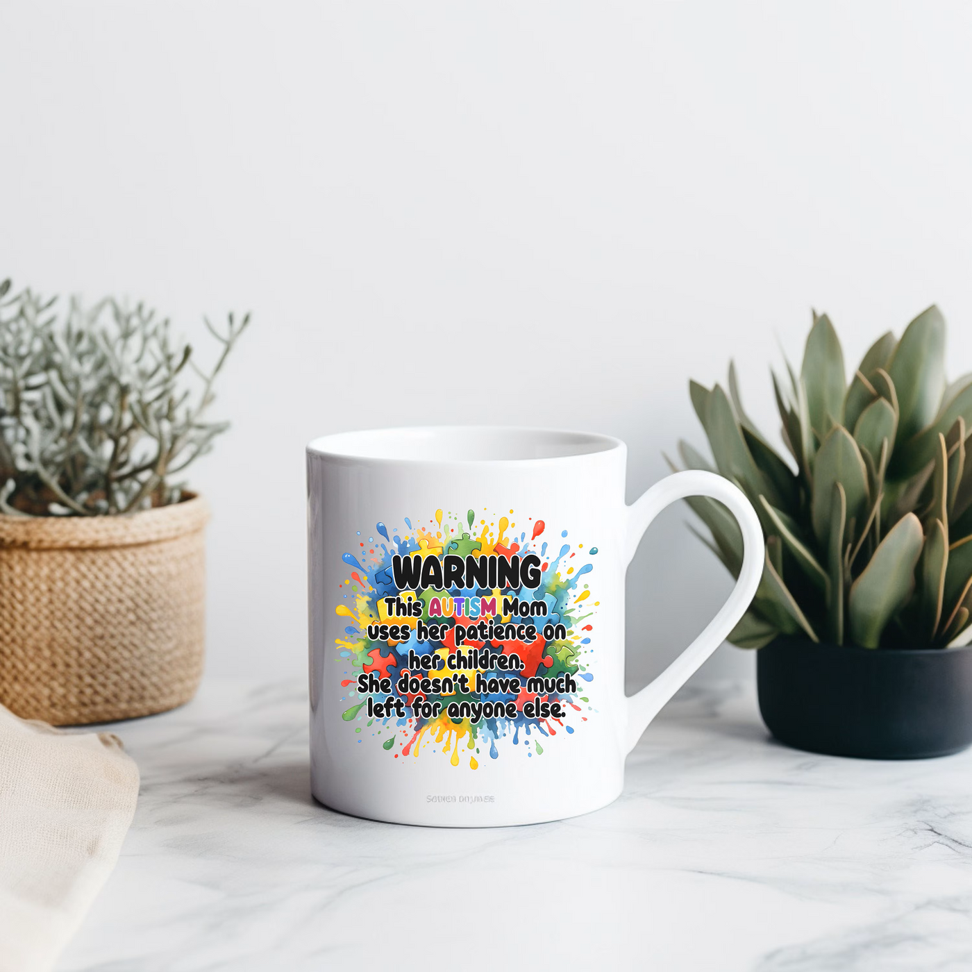 a coffee mug sitting on top of a table next to a potted plant