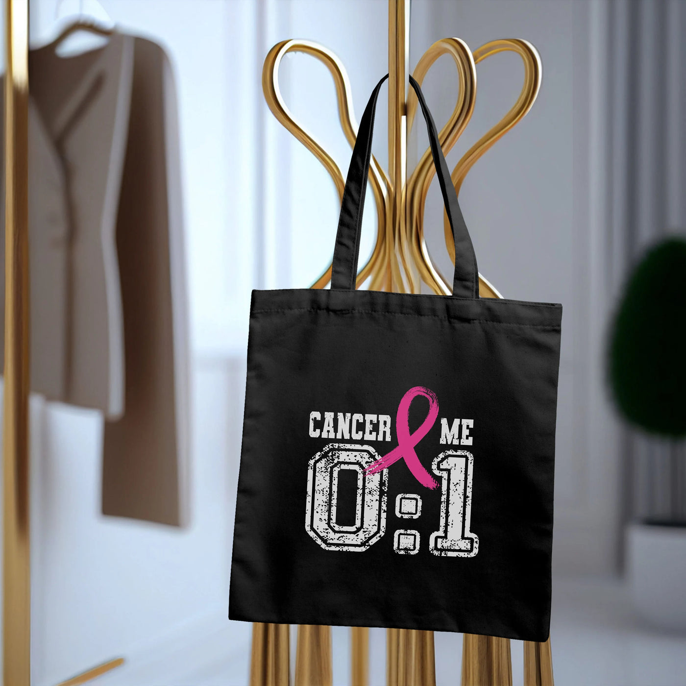 a black shopping bag with a pink ribbon on it