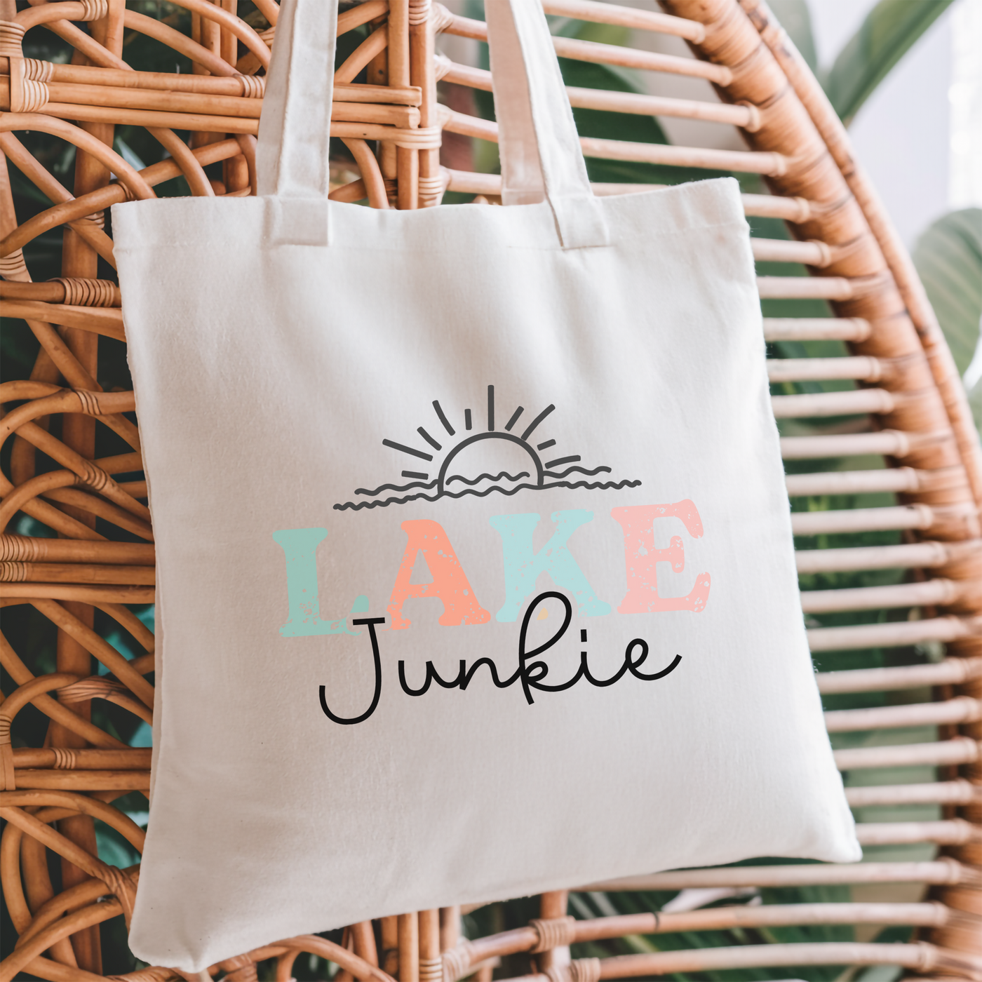 a lake junkie tote bag hanging on a wicker chair