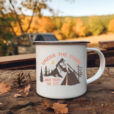 a camp mug sitting on the ground next to leaves