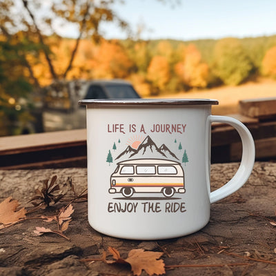 a camper mug sitting on the ground next to leaves