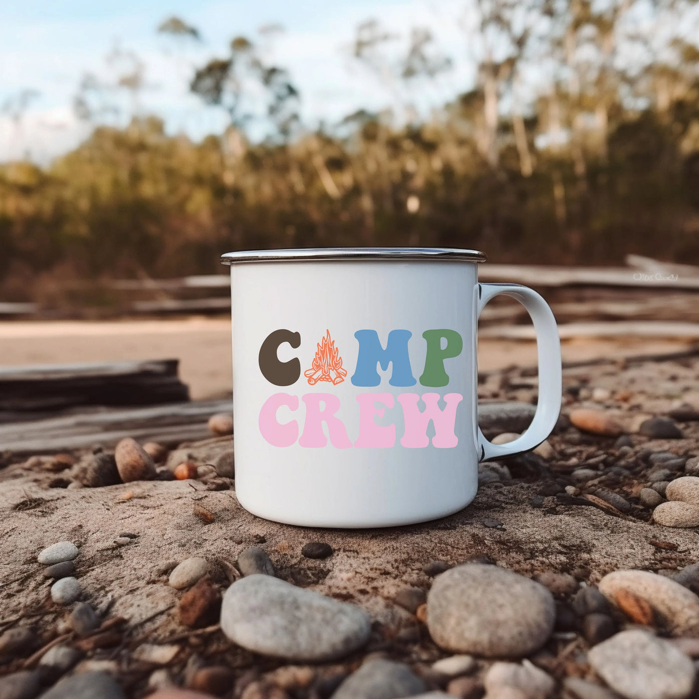 a camp crew camp mug sitting on a rock