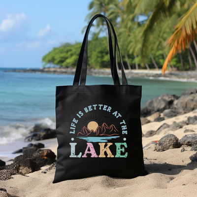 a black tote bag sitting on top of a sandy beach