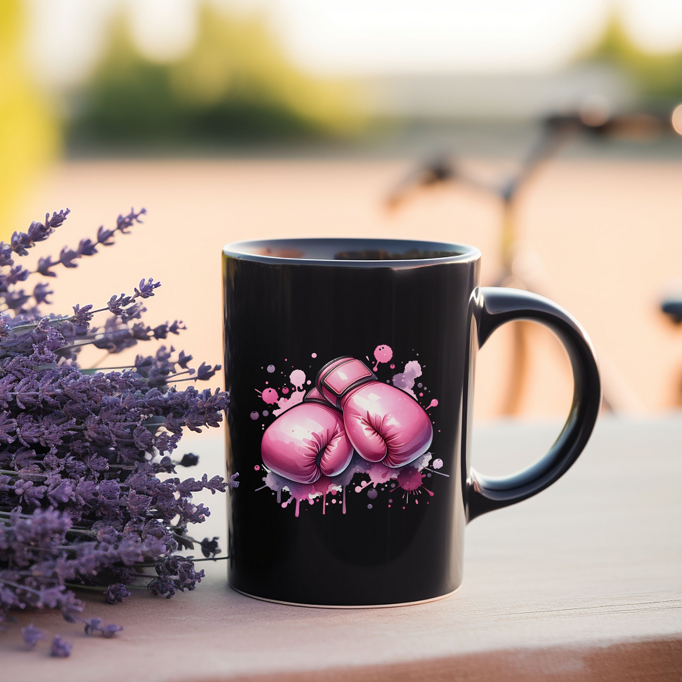 a black coffee mug with pink boxing gloves on it