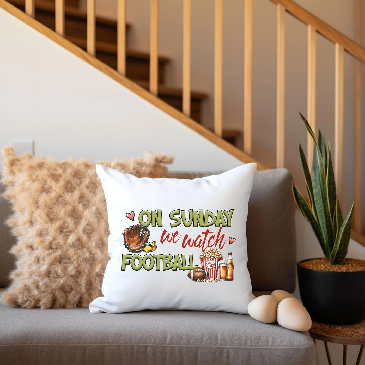 a white pillow sitting on top of a couch next to a plant