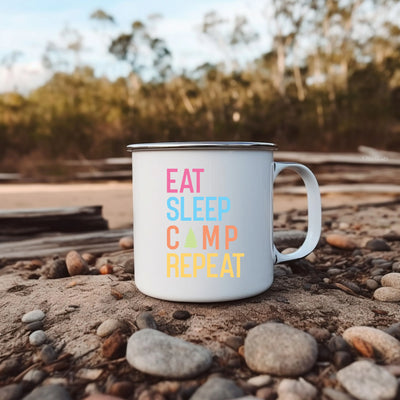 a white camp mug sitting on top of a pile of rocks