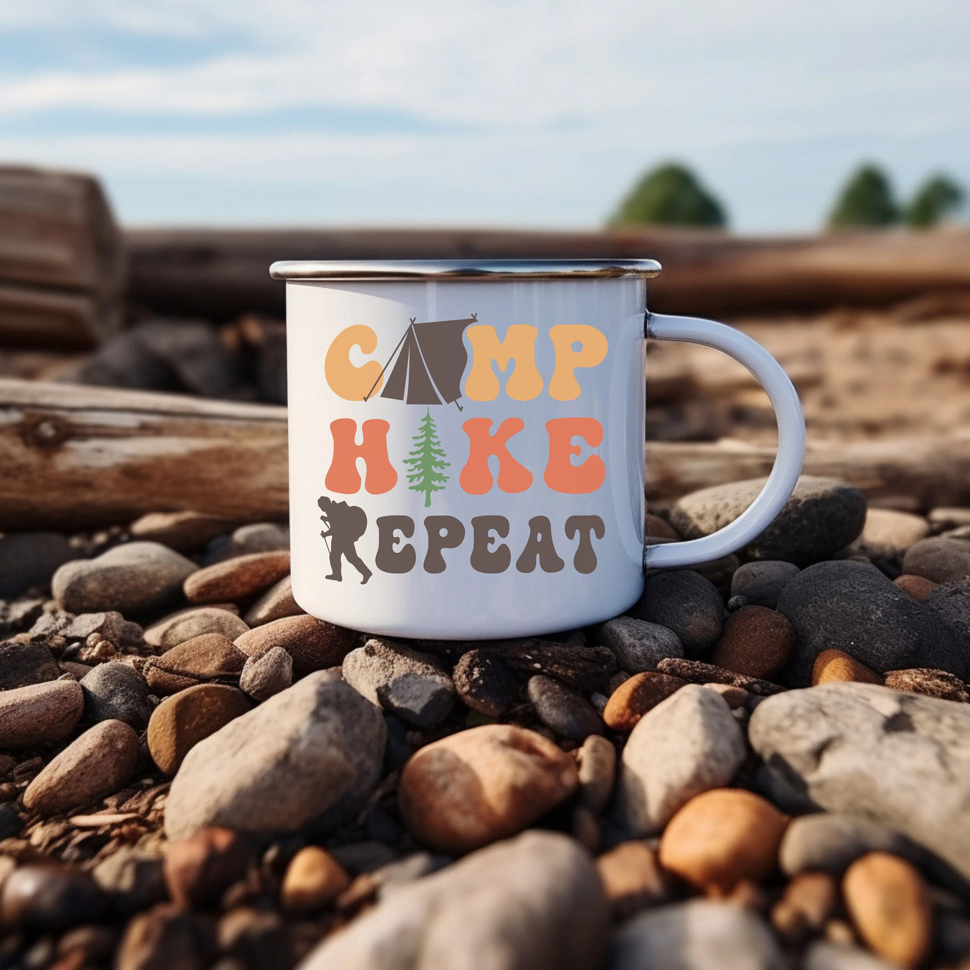 a camp mug sitting on a rocky beach