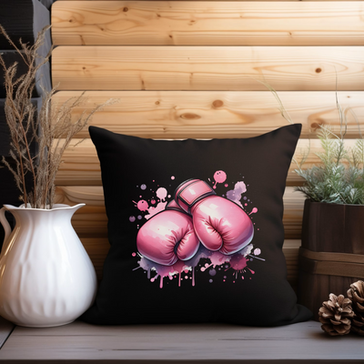 a black pillow with pink boxing gloves on it