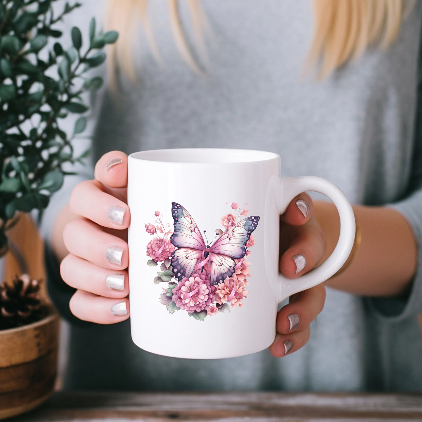 a woman holding a coffee mug with a butterfly on it