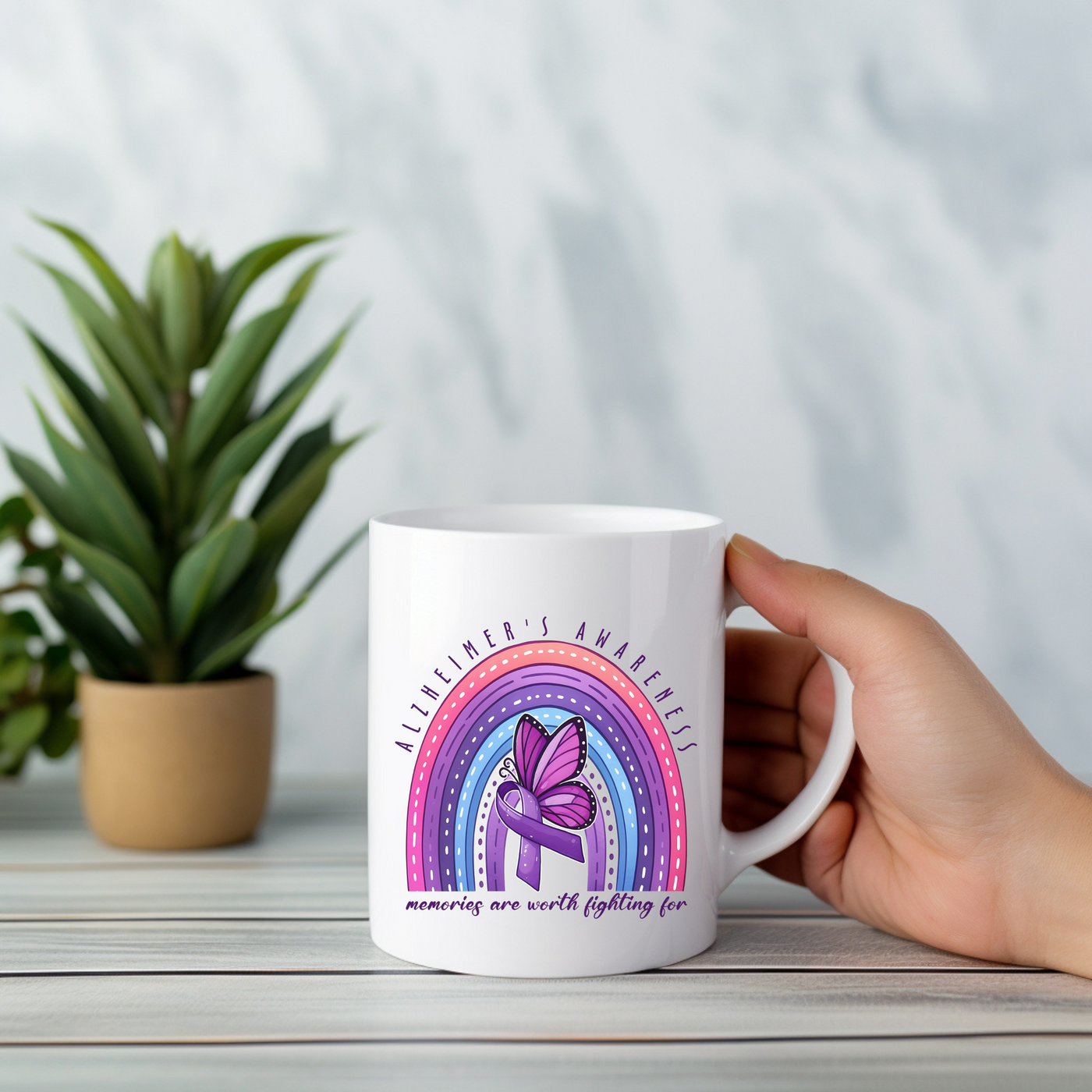 a person holding a coffee mug with a rainbow in the background