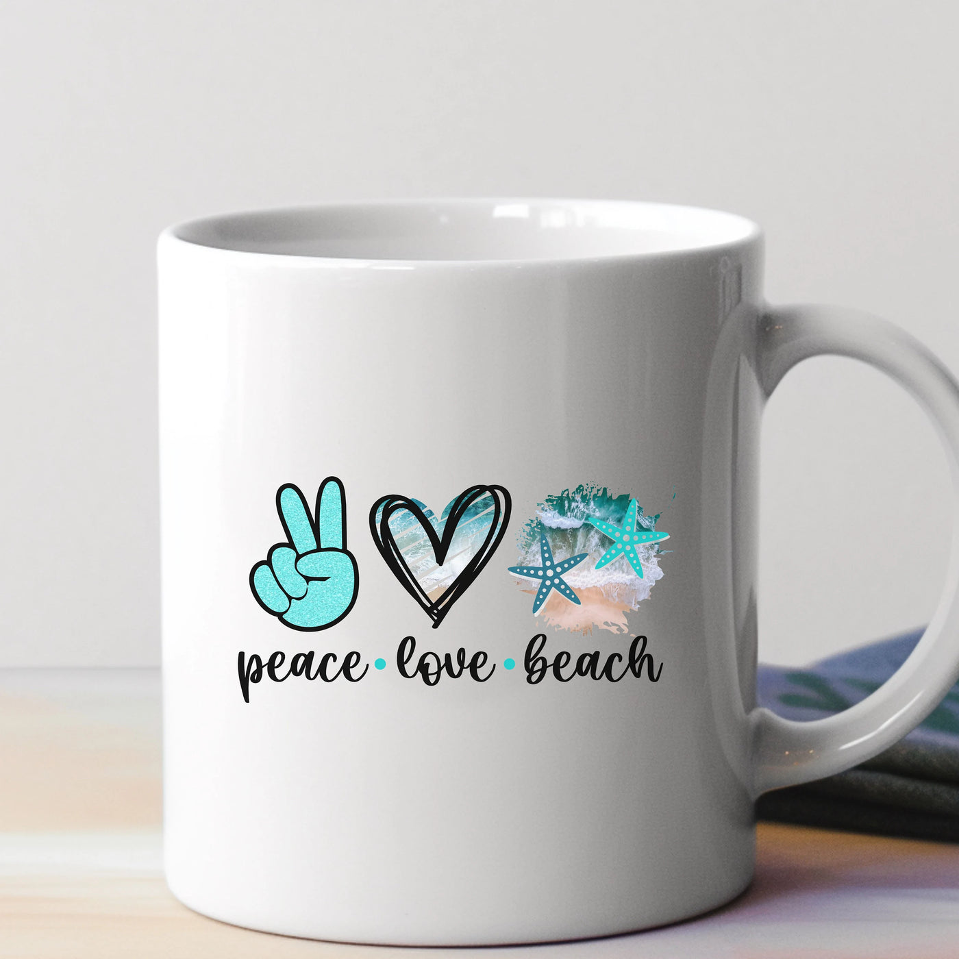 a white coffee mug with peace and love beach written on it