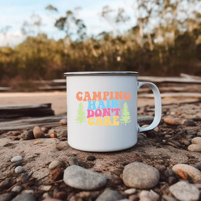 a white camp mug sitting on top of a pile of rocks