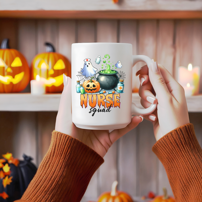 a person holding a coffee mug with a halloween scene on it