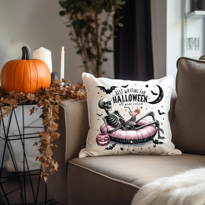 a halloween pillow sitting on a couch next to a potted plant