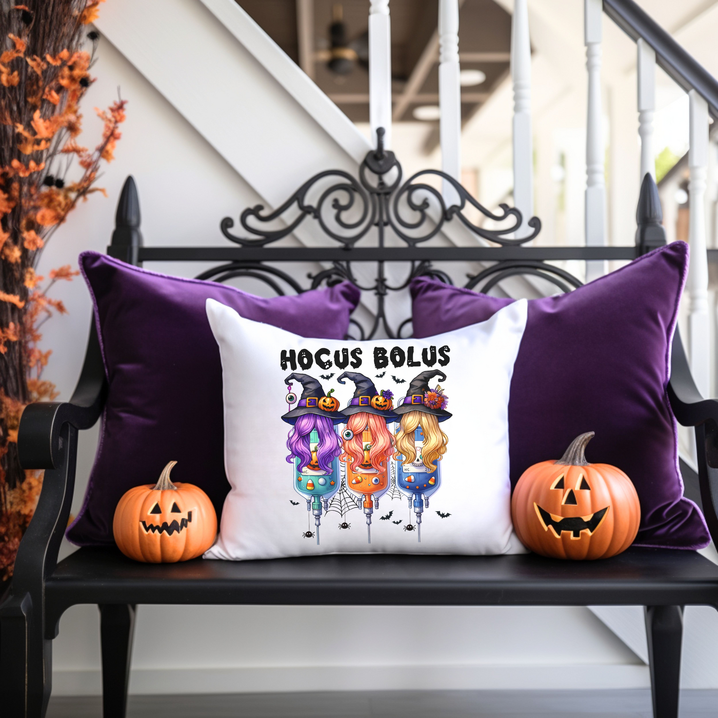 a black bench with two pumpkins and a pillow on it