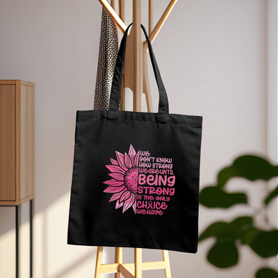 a black shopping bag with a pink flower on it