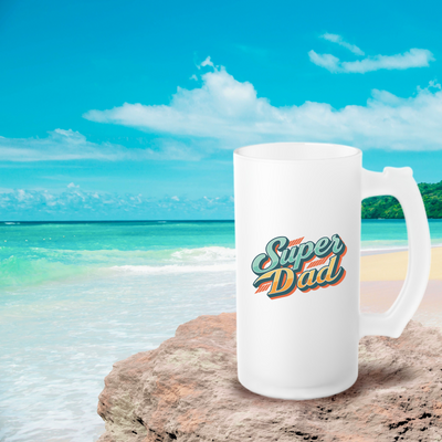 a white coffee mug sitting on top of a sandy beach