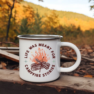 a campfire mug sitting on a log in the woods