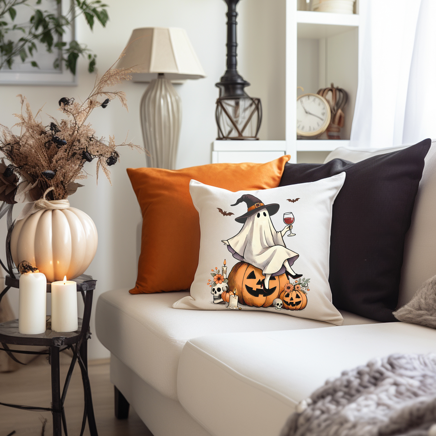 a living room with a white couch and a halloween pillow