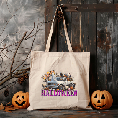 a tote bag sitting next to two pumpkins