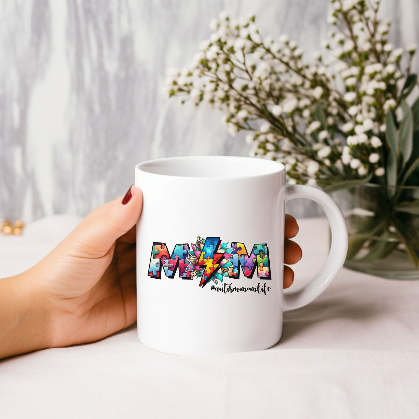 a person holding a coffee mug with the word mom on it